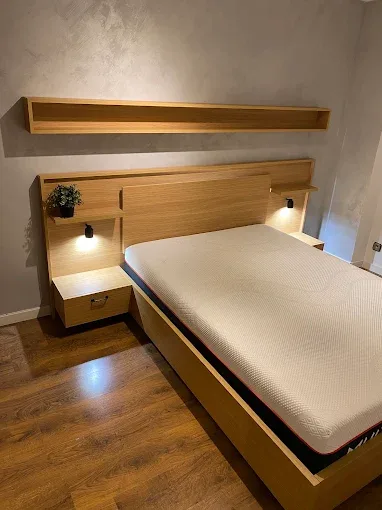 Cama de roble con mesitas flotantes y luz